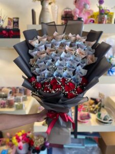 Large cash bouquet with 100000 rupees in various denominations and red roses with baby's breath