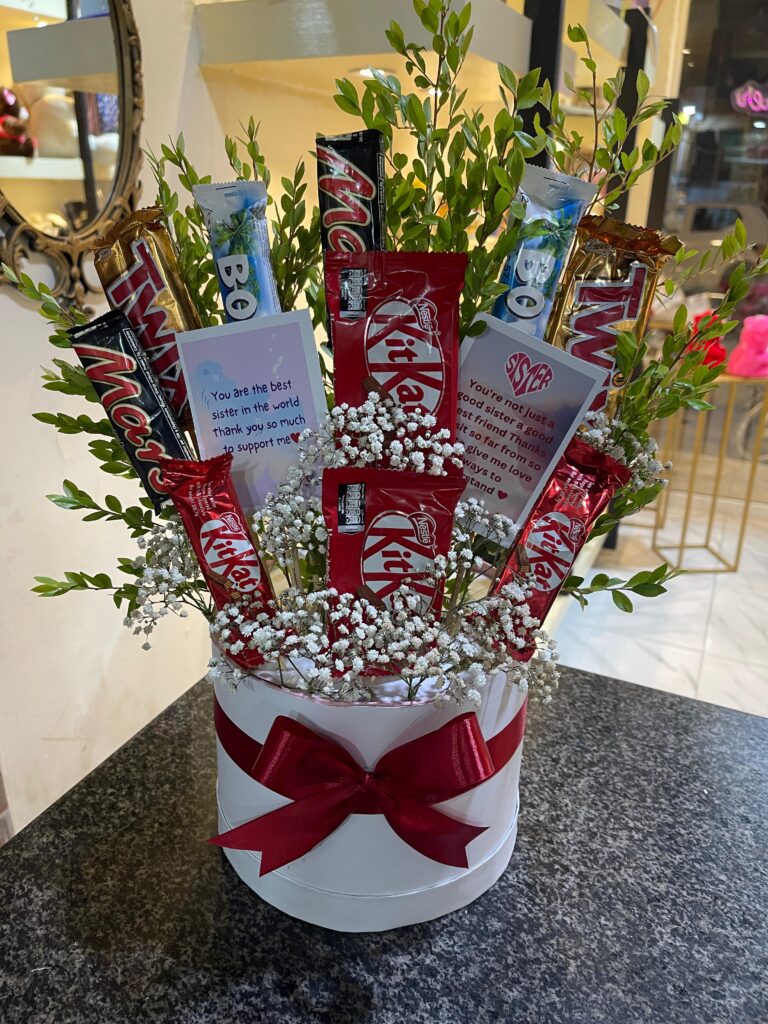 Premium Custom Bloom Chocolate Box with fresh baby breath flowers and assorted chocolates including KitKat, Twix, Mars, and Bounty, beautifully arranged in a white round gift box by Giftyfy