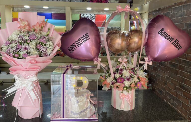 Pink birthday gift set with fresh flower bouquet, custom name balloons, and acrylic cake box with LED letter in Pakistan